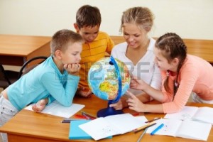 10325372-portrait-of-cute-schoolchildren-and-teacher-looking-at-globe-in-classroom